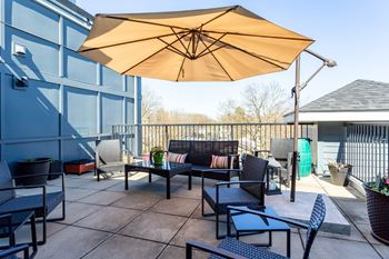a patio with tables and chairs and an umbrella